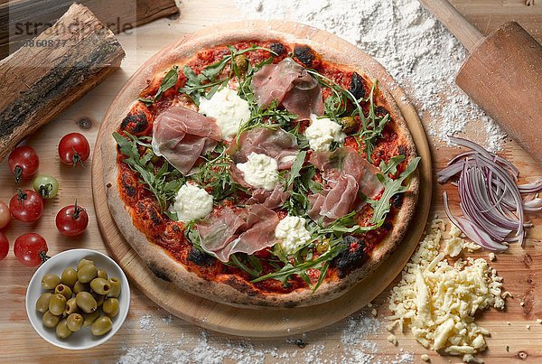 Draufsicht auf Parmaschinken-Pizza mit grünen Oliven