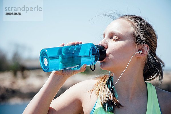 Frau trinkt Wasser aus Plastikflasche