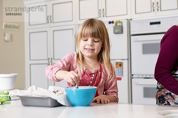 Mädchen mischt Kuchen an der Küchentheke