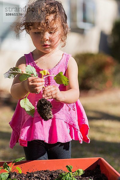 Junges Mädchen im Garten  hält Pflanze