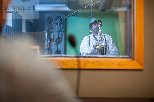 Männlicher Musiker im Aufnahmestudio  spielt Saxophon