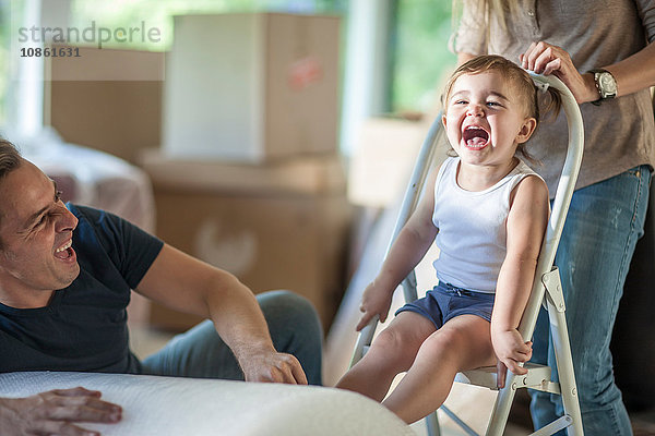 Umzug: Vater und Tochter lachen  Tochter sitzt auf einem Tritthocker