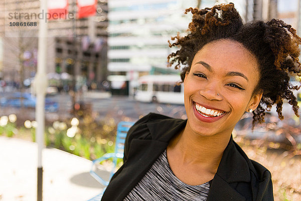 Porträt einer jungen Geschäftsfrau  lächelnd  im Freien