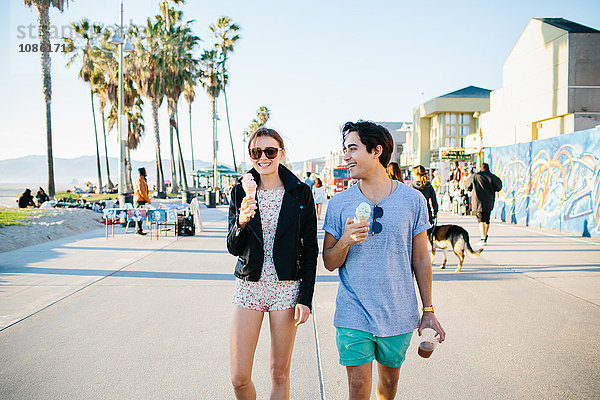 Junges Paar beim Spaziergang mit Eiswaffeln  Venice Beach  Kalifornien  USA
