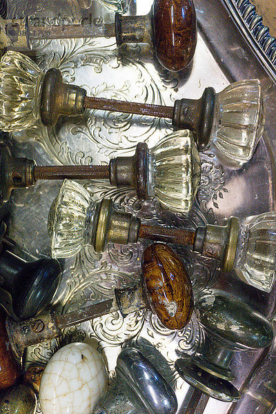 Draufsicht mit verschiedenen antiken Türknöpfen auf Silbertablett