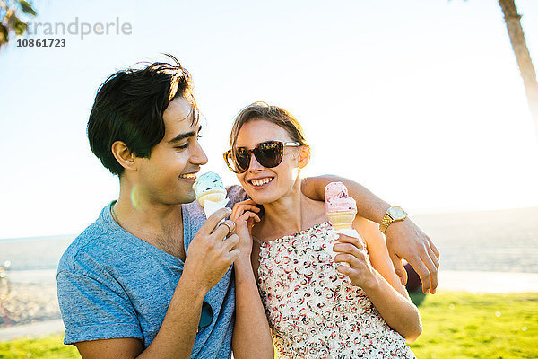 Romantisches junges Paar an der Küste beim Essen von Eistüten  Venice Beach  Kalifornien  USA