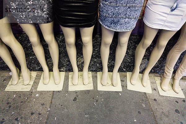 Detail von sechs weiblichen Puppen auf dem Bürgersteig  die Miniröcke tragen