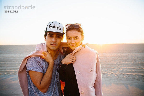 Porträt eines jungen Paares in einen Mantel gehüllt am Strand  Venice Beach  Kalifornien  USA