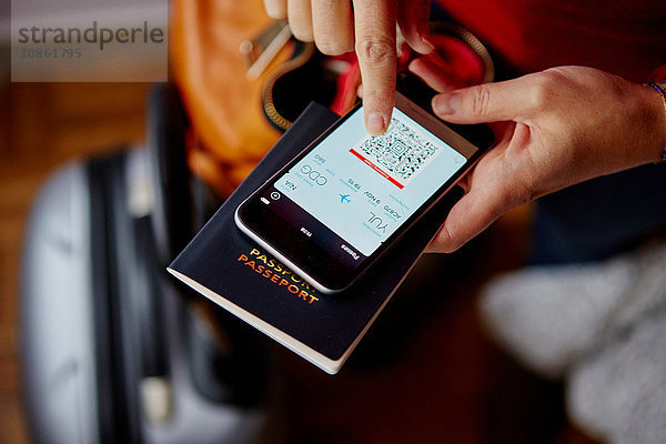 Frau mit Reisepass und Smartphone  Smartphone mit QR-Code  Draufsicht