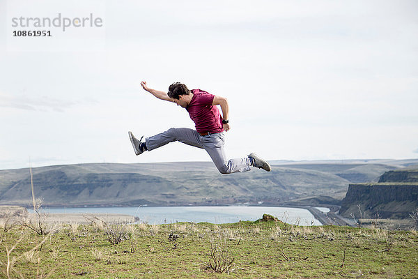 Mann springt  in der Luft  auf den Berggipfel  Kolumbien-Flussschlucht  Washington  USA