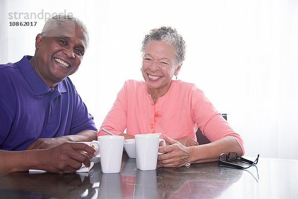 Porträt eines älteren Ehepaares beim Frühstück  lächelnd