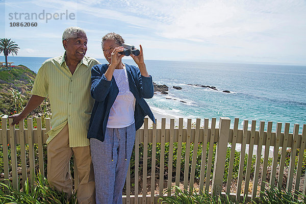 Älteres Paar im Freien  Frau schaut durch ein Fernglas  schaut auf die Aussicht