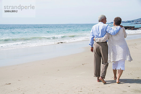 Älteres Paar beim Aufwachen am Strand  Rückansicht