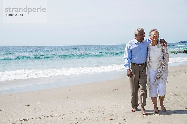 Älteres Ehepaar wacht gemeinsam am Strand auf und lächelt