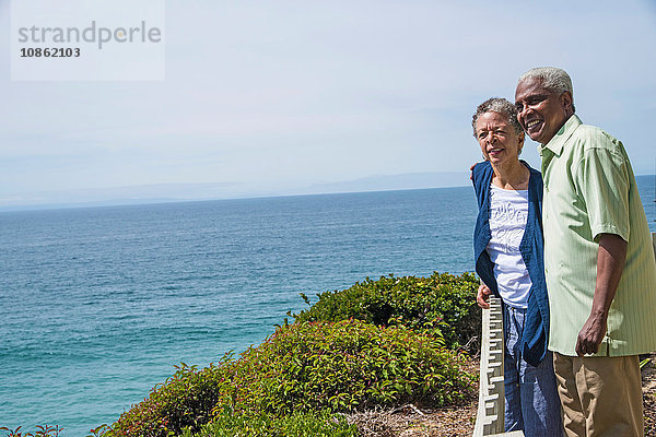 Älteres Ehepaar steht draußen  in der Nähe des Ozeans  schaut auf die Aussicht