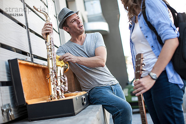 Straßenmusikant putzt Saxophon