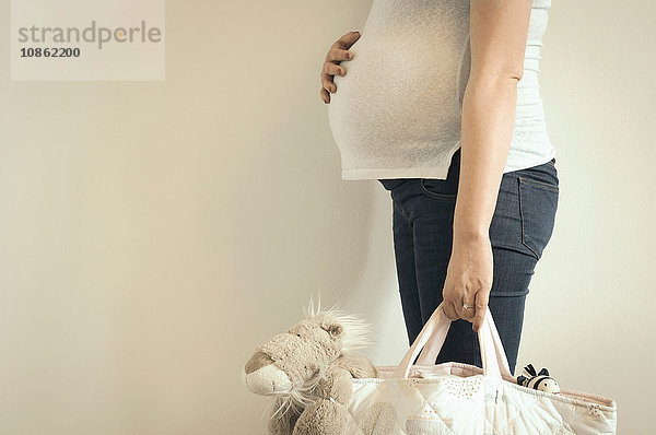 Schwangere Frau  Haltetasche mit Kuscheltier darin  Mittelteil