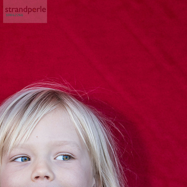 Schrägansicht eines blondhaarigen Jungen  der wegschaut