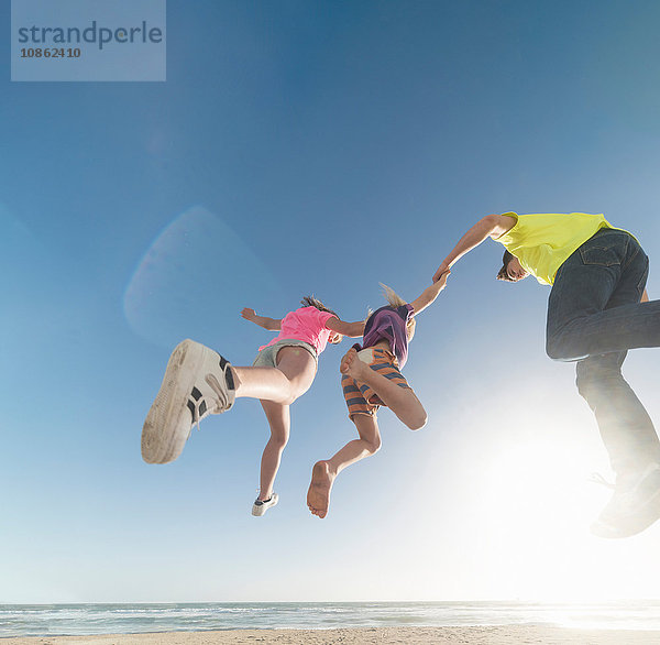 Freunde springen auf dem Seeweg in die Luft