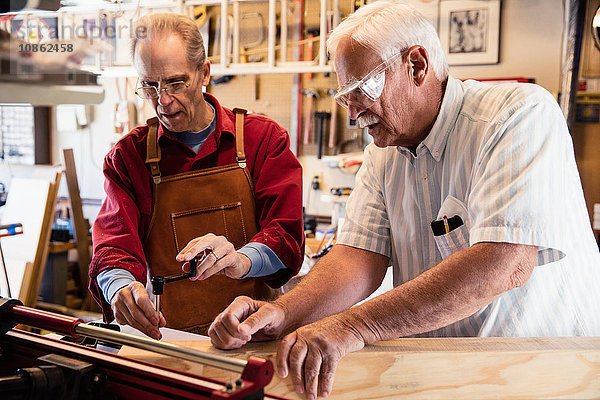 Ältere Männer  die mit der Werkstatt für Tischlereiausrüstung arbeiten