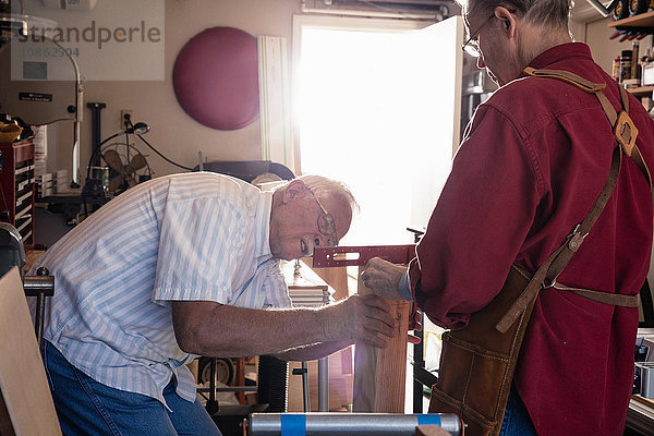 Ältere Männer überprüfen Wasserwaage in Schreinerei
