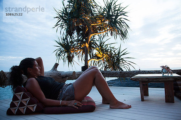 Reife Frau entspannt sich in der Dämmerung auf der Terrasse  mit Blick auf die Aussicht  Koh Lanta  Thailand