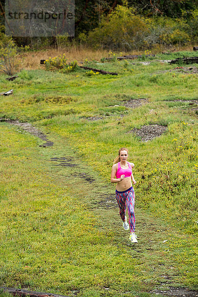 Hochwinkelaufnahme einer jugendlichen Läuferin  die im Park läuft