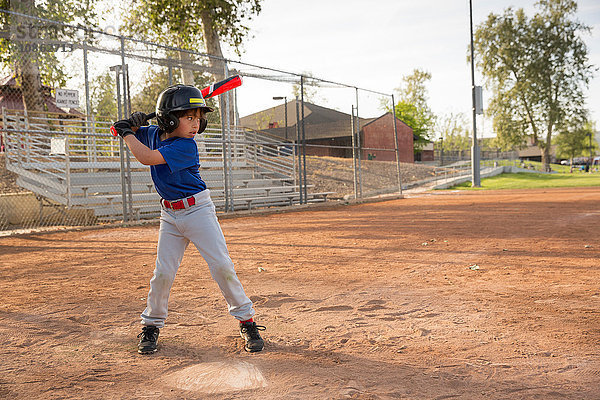 Junge schlägt beim Training auf dem Baseballfeld