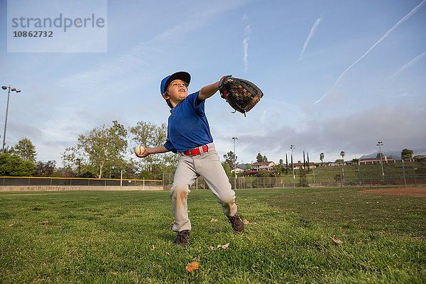 Junge wirft Ball beim Training auf dem Baseballfeld