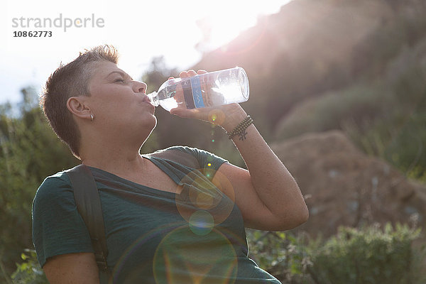 Frau trinkt Wasser aus Plastikflasche