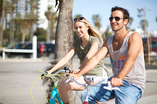 Ein glückliches Paar radelt gemeinsam am Venice Beach  Los Angeles  Kalifornien  USA