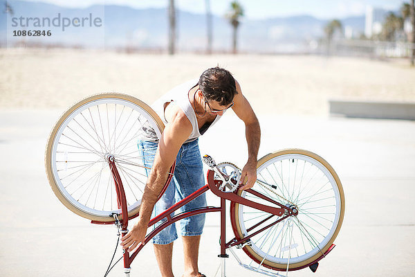 Mann repariert Fahrrad in Venice Beach  Los Angeles  Kalifornien  USA