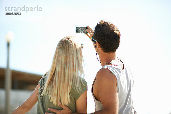 Rückansicht eines Paares beim Smartphone-Selfie am Venice Beach  Los Angeles  Kalifornien  USA