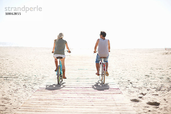 Rückansicht eines radfahrenden Paares an der Strandpromenade von Venice Beach  Los Angeles  Kalifornien  USA