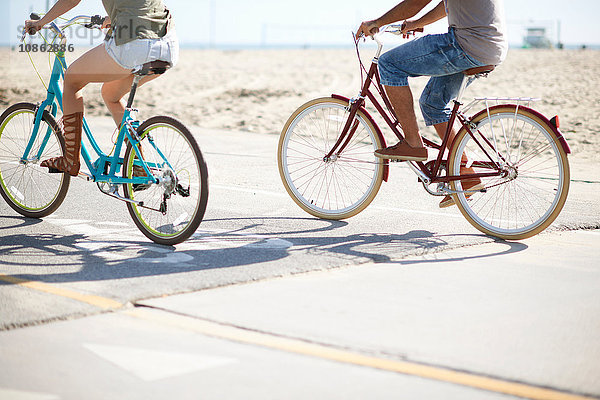 Blick von unten auf das Fahrrad fahrende Paar am Venice Beach  Los Angeles  Kalifornien  USA