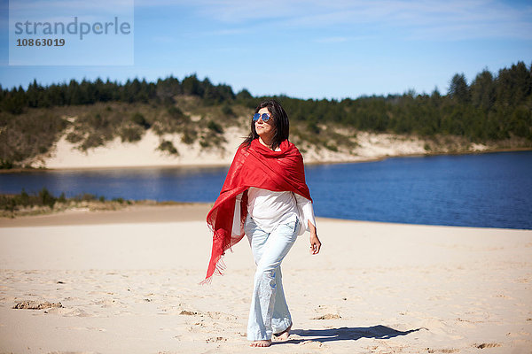 Frau im roten Tuch genießt Strand