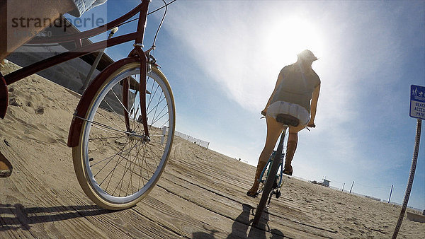 Niedrigwinkelaufnahme eines Paares beim Radfahren an der Strandpromenade von Venice Beach  Kalifornien  USA