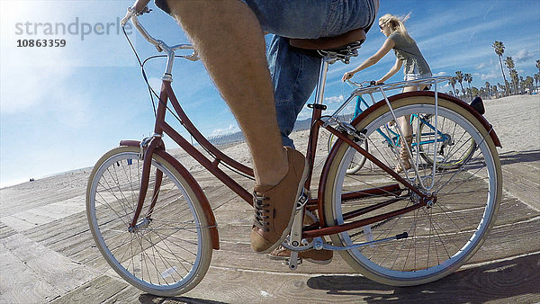 Niedrigwinkelaufnahme eines Radfahrerpaares an der Strandpromenade von Venice Beach  Kalifornien  USA