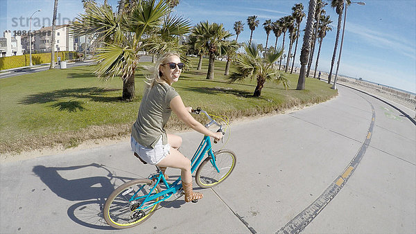 Porträt einer jungen Frau beim Radfahren am Venice Beach  Kalifornien  USA