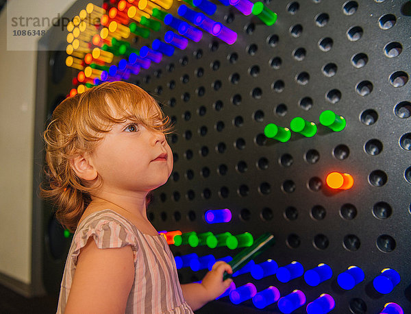 Weibliches Kleinkind durch bunte Leuchttafel hypnotisiert