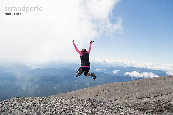 Junge Frau auf dem Berggipfel  Freudensprünge  Rückansicht  Mt. St. Helens  Oregon  USA