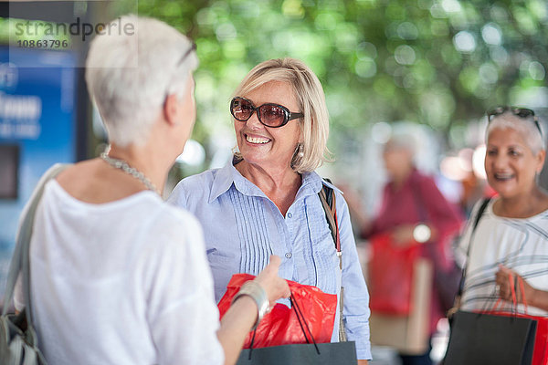 Ältere Frau und Freundin beim Einkaufen und Plaudern in der Stadt
