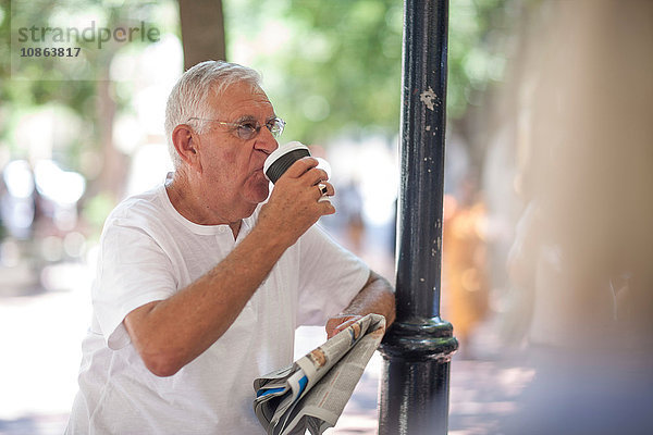 Älterer Mann trinkt Kaffee zum Mitnehmen in der Stadt