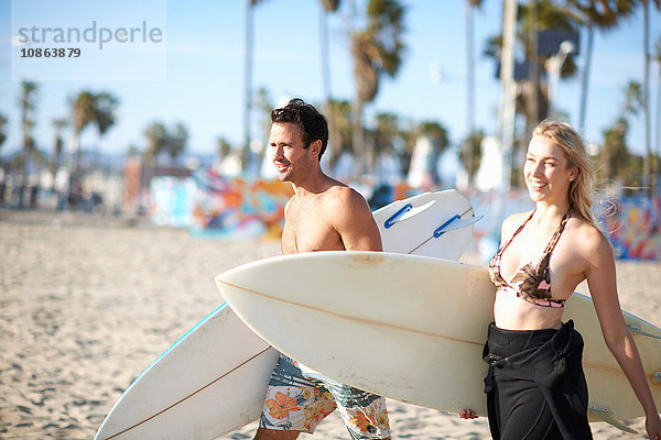 Surferpaar mit Surfbrettern am Strand von Venice Beach  Kalifornien  USA