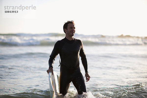 Im Meer stehender männlicher Surfer am Strand von Venice Beach  Kalifornien  USA