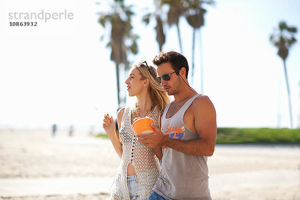 Spaziergang zu zweit und gemeinsame Nutzung von gefrorenem Joghurt am Venice Beach  Kalifornien  USA