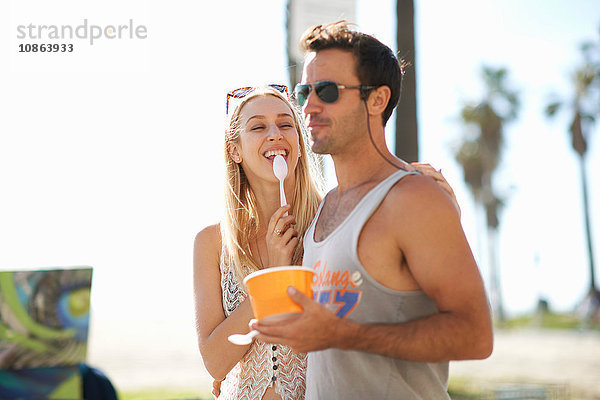 Paar beim Spaziergang und beim Verzehr von gefrorenem Joghurt am Venice Beach  Kalifornien  USA