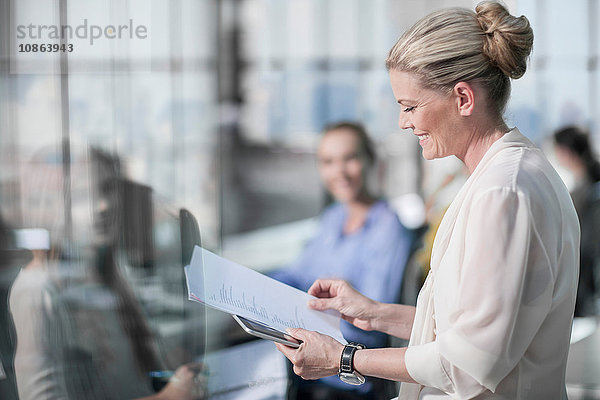 Weibliche Managerin liest Papierkram bei Besprechung im Büro