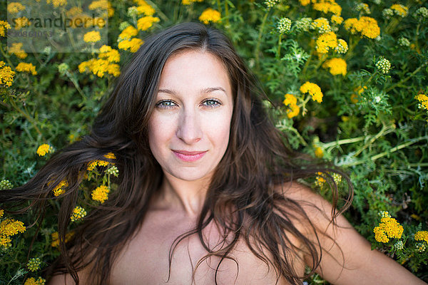 Frau liegt auf einem Feld mit Wildblumen