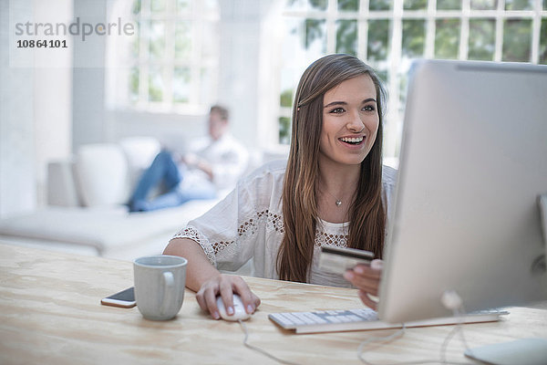 Frau  die beim Online-Shopping mit Kreditkarte bezahlt